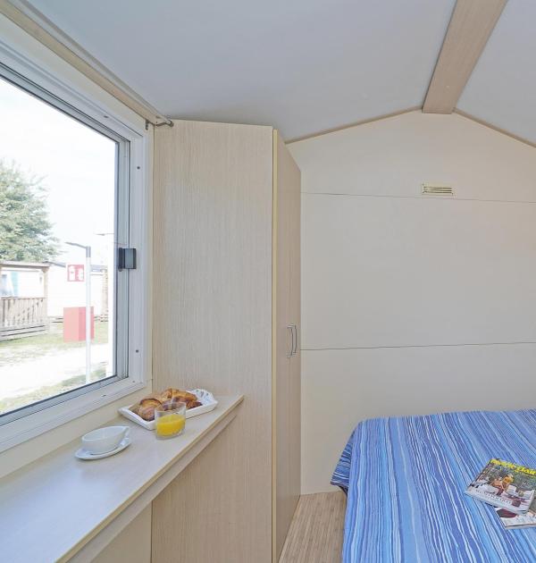 Zimmer mit Doppelbett, Zeitschriften und Frühstück.