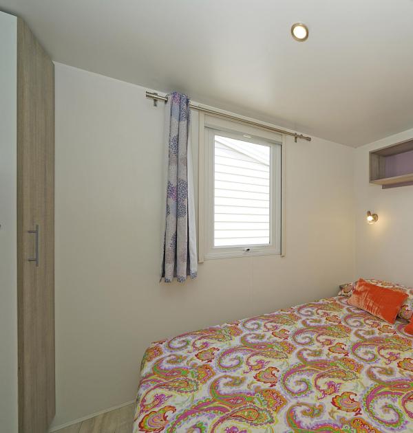 Bedroom with double bed and colorful decorations.